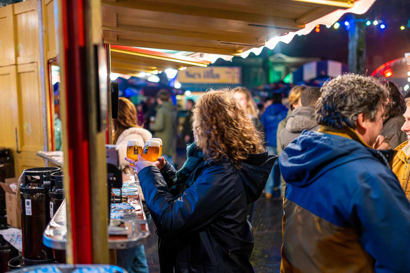 Bezoeker van speciaalbier festival met proefglaasjes bij de bar.